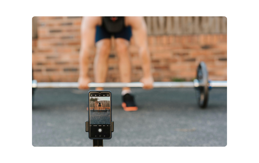 Smartphone recording a workout session, showcasing faceless videos as a strategy for creating engaging fitness content.